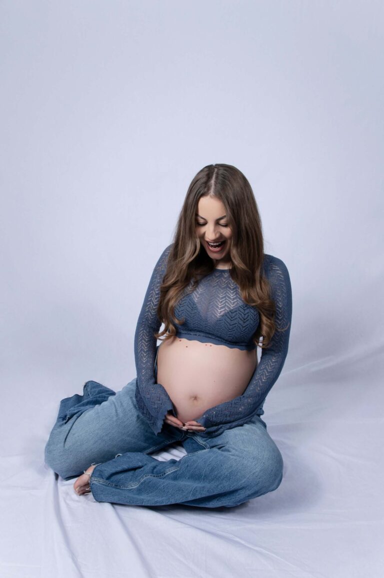 Fotografi på gravid kvinna som håller om sin mage.