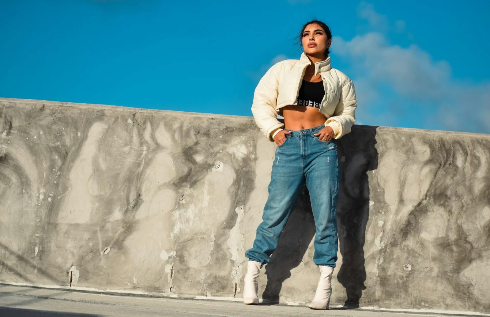 Modefoto utomhus på kvinnlig modell i cool klädsel.