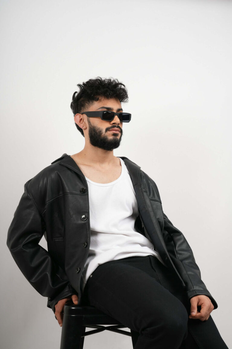 Manlig modell poserar i studioljus under fotosession.