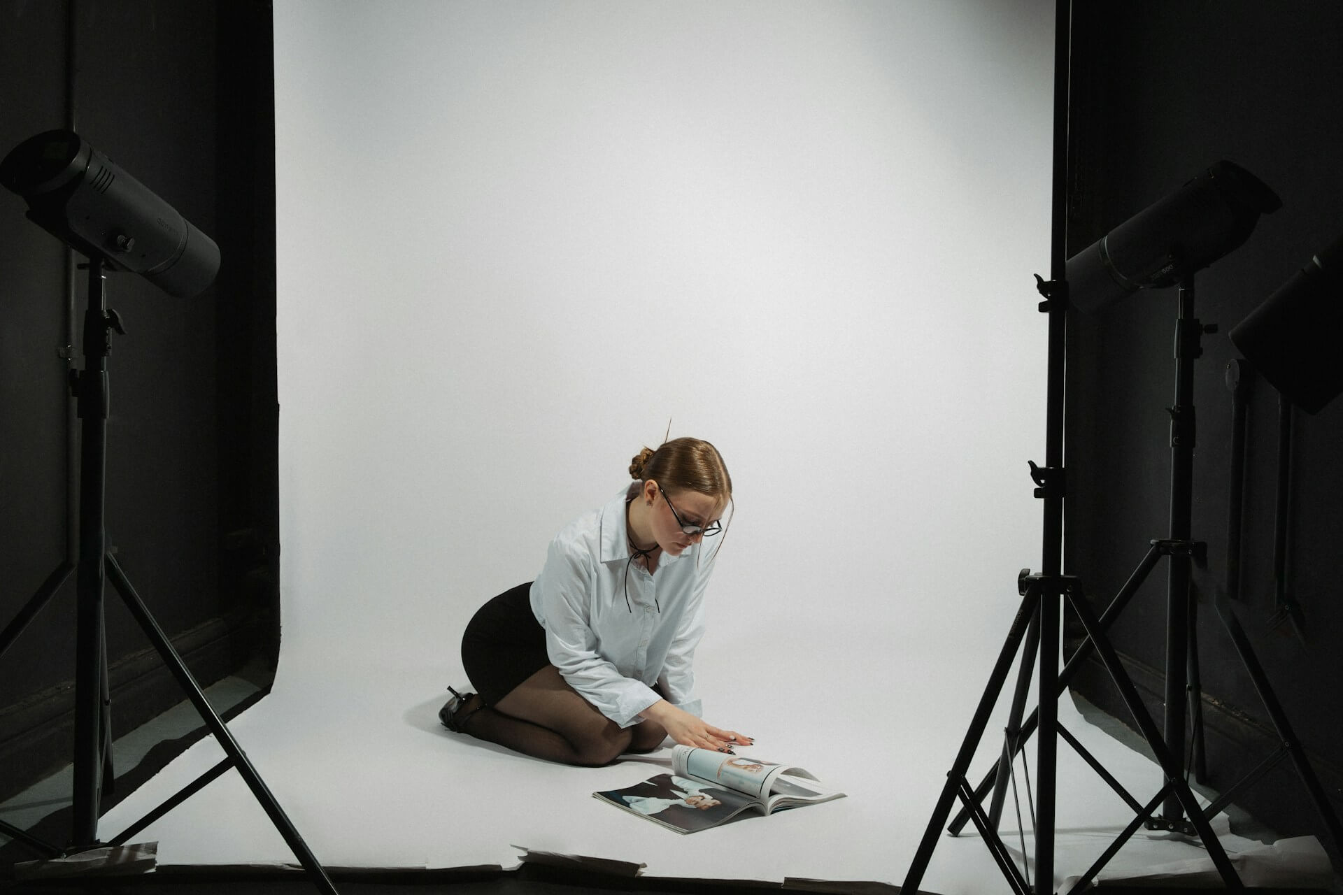 modell i fotostudio som läser igenom modellguide.