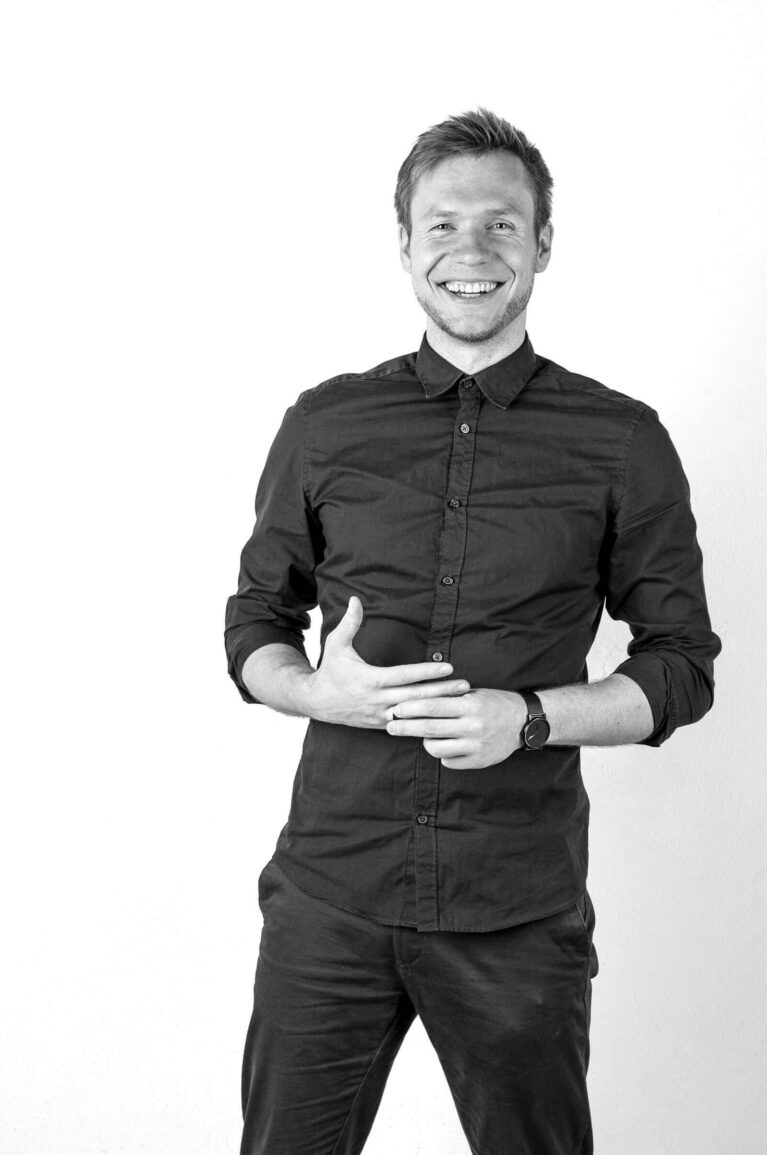 Svartvit porträttfoto på kille i fotostudio.