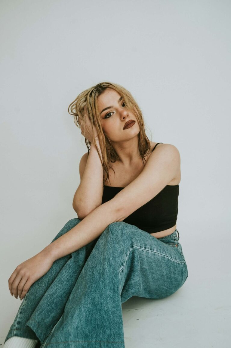 Modell som poserar sittandes för studiofotgrafering.